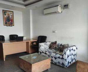 a living room with a couch and a desk at Hotel O Daffodils in Gurgaon