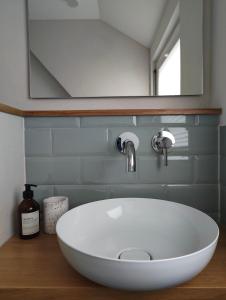 a white sink in a bathroom with a mirror at Apartments 11 in Forchheim