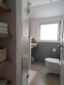 a bathroom with a white toilet and a window at Apartments 11 in Forchheim