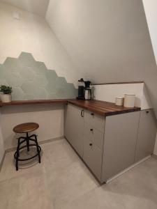 a small kitchen with a counter and a stool at Apartments 11 in Forchheim