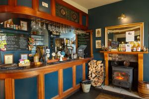 a bar in a restaurant with a fireplace at The Castle Hotel in Bishops Castle