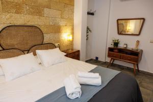 a bedroom with a bed with two towels on it at La Casa del Risco Zahara in Zahara de la Sierra
