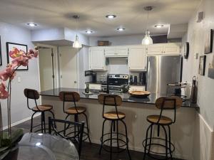 a kitchen with a counter with stools in it at Gated Lakefront Retreat in Edmond