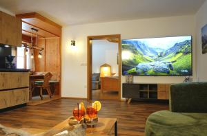 a living room with a flat screen tv on a wall at Ferienwohnungen Vogelrast in Berchtesgaden