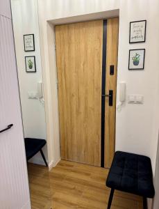 a wooden door in a room with a stool at Dan Apartament C, Self check-in in Opole +2 photos