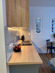 a kitchen with a sink and a bowl of fruit on a counter at Dan Apartament C, Self check-in in Opole