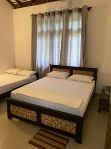 two twin beds in a room with a window at Sthupa Horizon in Anuradhapura