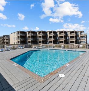 a swimming pool in front of a apartment building at Ocean Dream in Kitty Hawk Beach