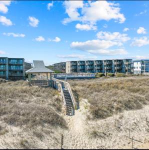 a building on the beach with a staircase and a building at Ocean Dream in Kitty Hawk Beach