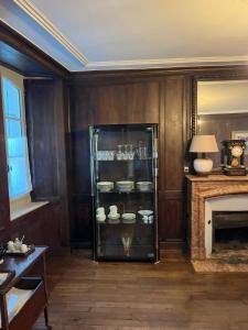 a room with a glass refrigerator with dishes in it at Les Glycines 23300 in La Souterraine