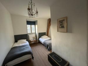 a bedroom with two beds and a chandelier at Les Glycines 23300 in La Souterraine