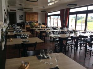 a restaurant with tables and chairs with wine glasses at Hotel Restaurant Pecoitz in Saint-Jean-Pied-de-Port