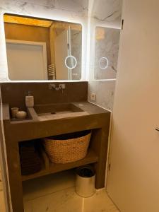a bathroom with a sink and a mirror at Les Suites in Strasbourg