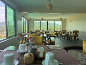 a dining room with tables and chairs and windows at Mara Balanite Hotel in Masai Mara