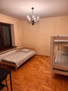 a bedroom with two beds and a chandelier at Noclegi na Asfaltowej in Sulejówek