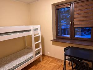 a bedroom with bunk beds and a desk and a window at Noclegi na Asfaltowej in Sulejówek