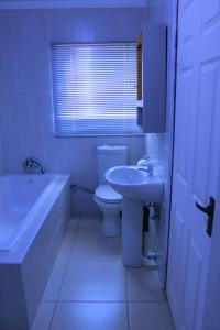 a bathroom with a toilet and a tub and a sink at Bataung Guest House in Mafeteng