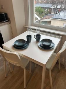 a white table with two glasses and plates on it at 1 Bed Room Flat Close to seafront in Weston-super-Mare +4 photos