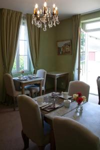 a dining room with a table and chairs and a chandelier at Les chambres du Domaine Rollan de By in Bégadan