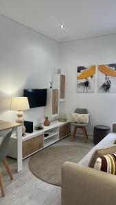 a living room with a couch and a tv at AMMO in Olhão