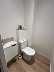 a white bathroom with a toilet and a sink at Arcade & Gaming Lodge in Trans-en-Provence