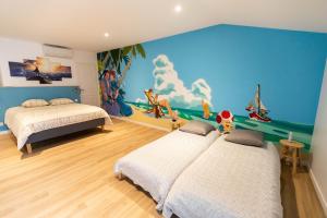 a bedroom with two beds and a mural on the wall at Arcade & Gaming Lodge in Trans-en-Provence