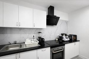 a kitchen with white cabinets and a sink at Casa Silva Diamond in Pinhal Novo