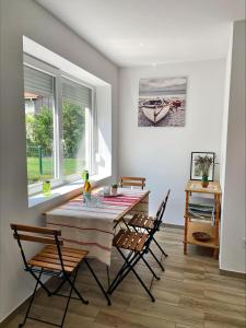 a dining room with a table and chairs and a window at Alma2 Vendégház in Révfülöp