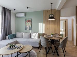 a living room with a couch and a table and chairs at Avenue Apartments Ilinden in Ilinden
