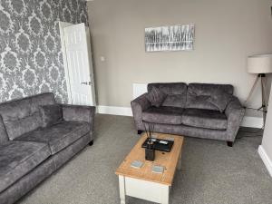 a living room with two couches and a coffee table at Pleasure Beach View in Blackpool