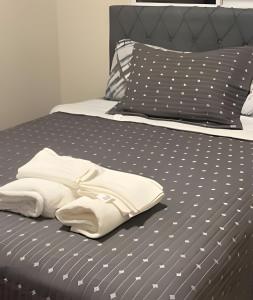 a bed with a pair of white shoes on it at Fátima Prime Loft + Breakfast in Extrema