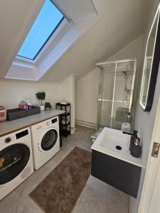 a bathroom with a washing machine and a sink at Cozy 3-Bedroom Home in Forus in Stavanger
