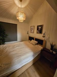 a bedroom with a large bed and a chandelier at Cozy 3-Bedroom Home in Forus in Stavanger