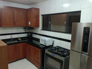 a kitchen with a stove and a microwave at Casa em Pedra Azul in Domingos Martins