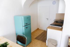 a blue refrigerator in a kitchen with a table at raum life - Design Apartment mit Küche in der Altstadt in Regensburg +23 photos