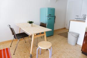 a table and chairs in a kitchen with a refrigerator at raum life - Design Apartment mit Küche in der Altstadt in Regensburg