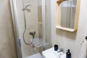 a bathroom with a shower and a sink and a mirror at raum life - Design Apartment mit Küche in der Altstadt in Regensburg