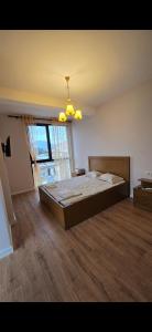 a bedroom with a large bed and a large window at Star Residence in Tirana