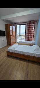 a large bed in a room with a large window at Star Residence in Tirana