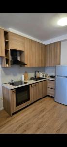a kitchen with wooden cabinets and a white refrigerator at Star Residence in Tirana