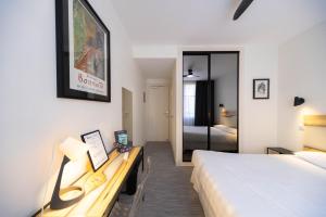 a hotel room with a bed and a desk with a bed sidx sidx at Trianon in Vichy