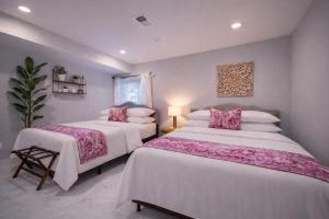 a bedroom with two beds with white sheets and pink pillows at Artsy Hidden Gem ll -Free Parking -- in Philadelphia