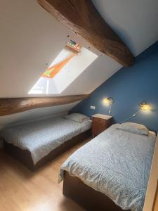 a attic bedroom with two beds and a window at Moulin Cottage - Germaines in Germaines