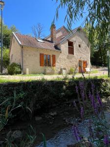 a stone house with a pond in front of it at Moulin Cottage - Germaines in Germaines