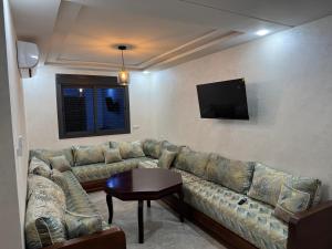 a living room with a couch and a flat screen tv at Saïdia Residence A - Plage accessible à pied in Saïdia