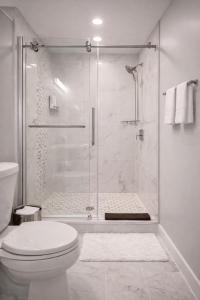 a white bathroom with a shower and a toilet at Artsy Hidden Gem ll -Free Parking -- in Philadelphia