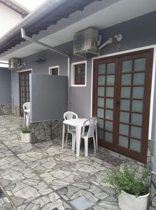 a patio with a table and chairs and a door at Recanto Mosaico in São Sebastião