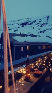 a table with wine glasses and lights on a balcony at Apartment Røldalsfjellet in Håra