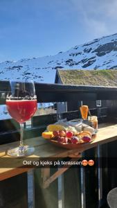 a glass of wine and a plate of food on a table at Apartment Røldalsfjellet in Håra +13 photos