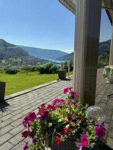 a patio with flowers and a view of the mountains at Stryn Central View in Stryn